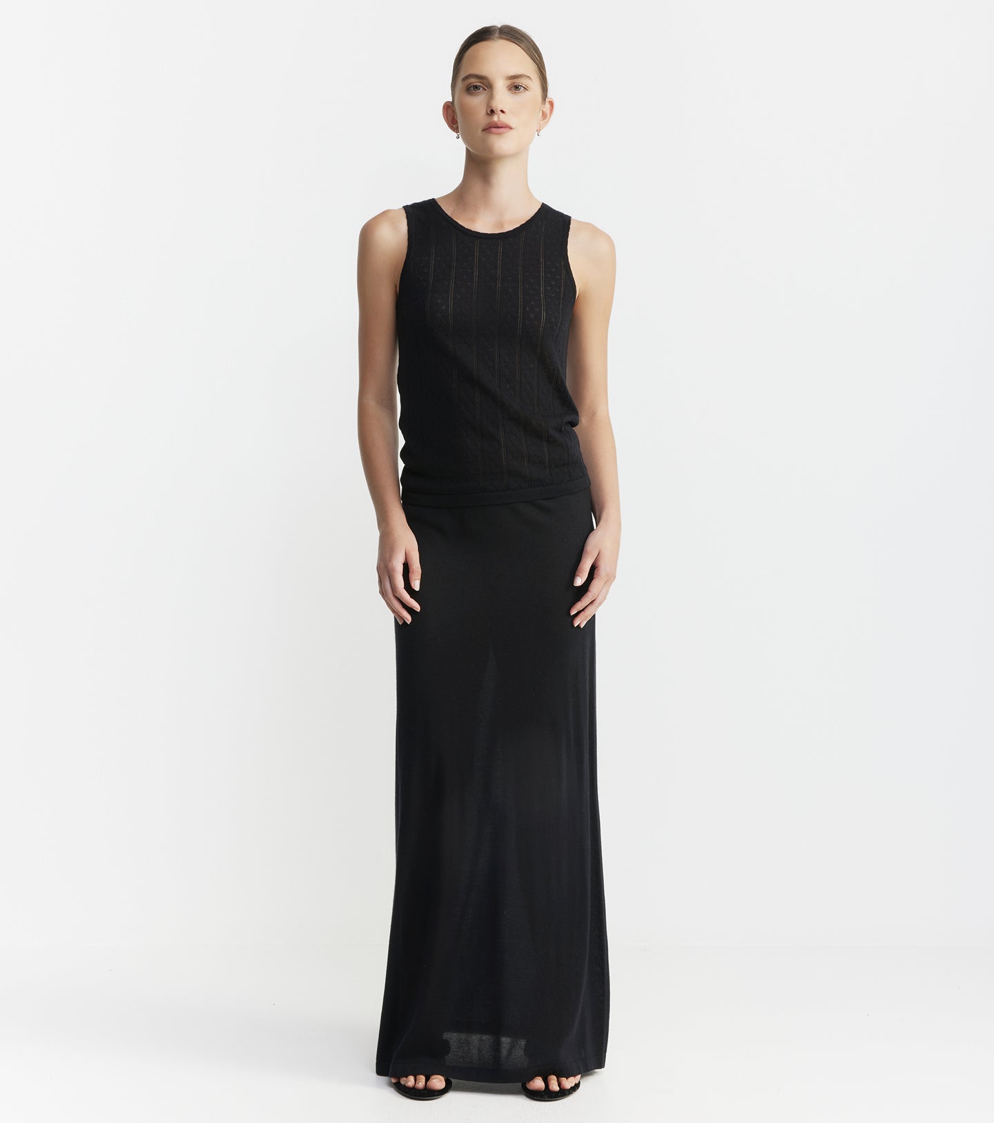 Woman wearing a black sleeveless gown on a white background