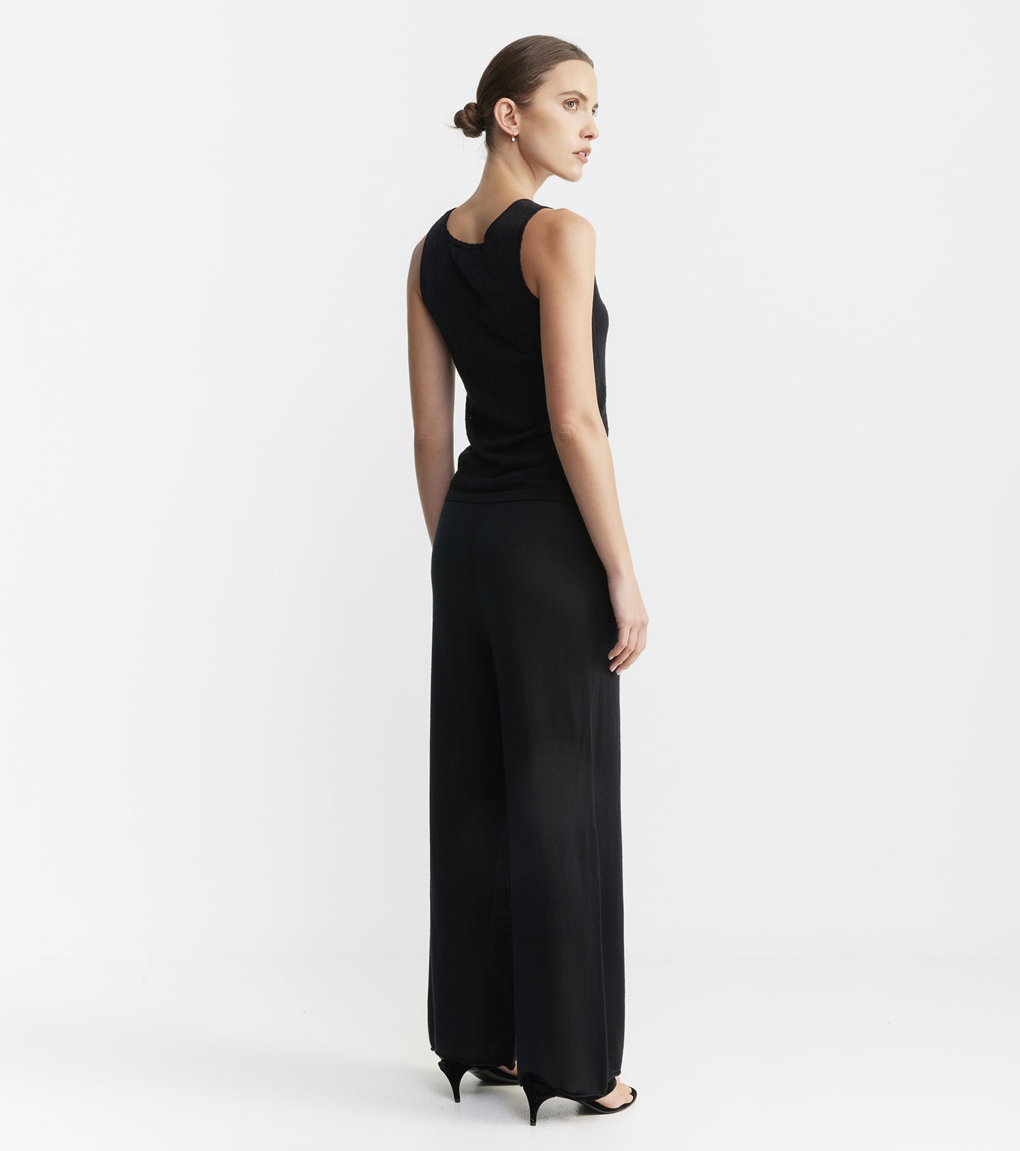 Woman wearing a black sleeveless dress on a white background